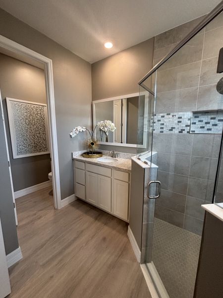 Large bathroom with a spacious glass-enclosed shower, dual vanity, and neutral tones.