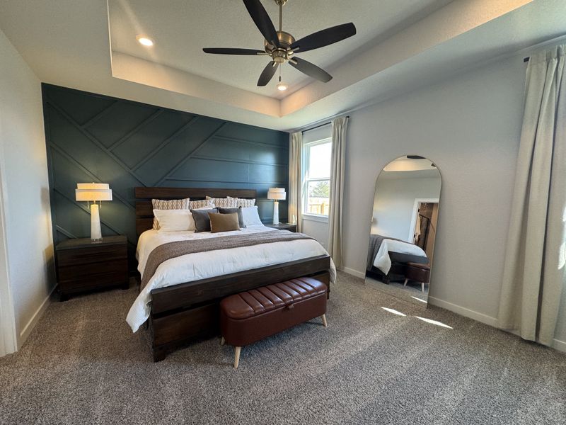 Modern bedroom featuring a geometric accent wall, plush bedding, and a stylish floor mirror. Modern bedroom featuring a geometric accent wall, plush bedding, and a stylish floor mirror.
