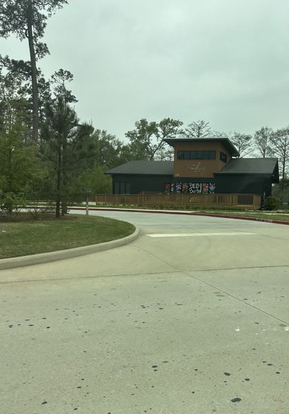 A modern building amidst lush greenery in Grand Central Park 50' by Perry Homes (Conroe, TX).