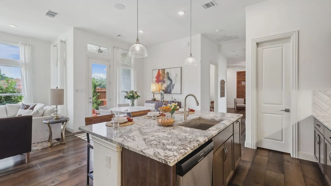 Elegant granite island and rich wood flooring highlight this Heritage Park kitchen's tasteful design.