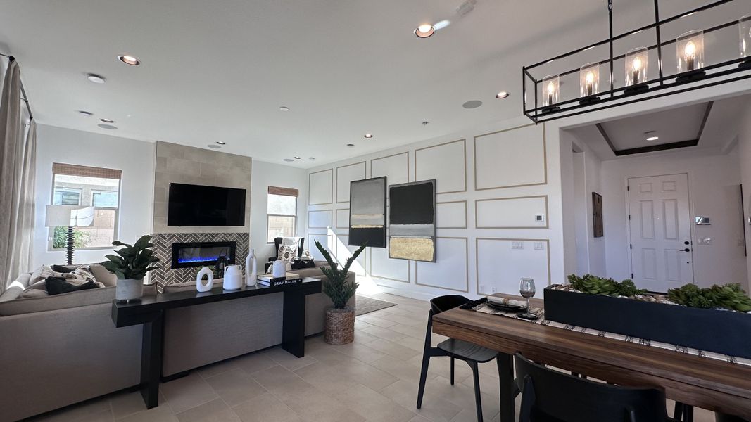 A modern living area with sleek furniture, contemporary fireplace, and elegant wall art, enhanced by ample natural light.