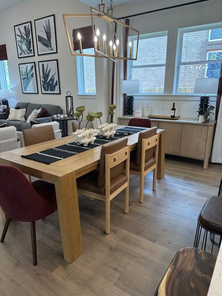 A cozy dining area with a wooden table, modern lighting, and stylish decor, featuring earthy tones and elegant wall art.