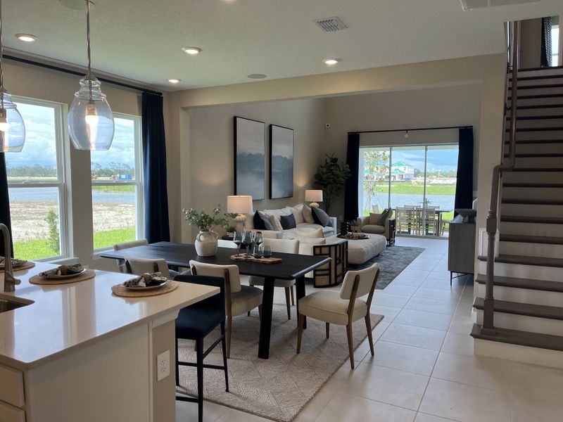 A contemporary open-concept living area with large windows, stylish furnishings, and serene lake views. A contemporary open-concept living area with large windows, stylish furnishings, and serene lake views.