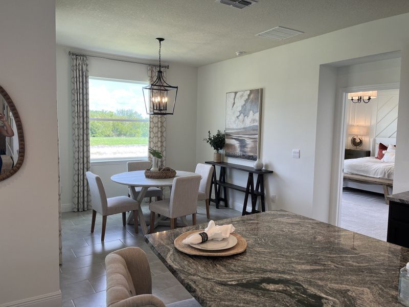 A cozy dining area with a round table, elegant lighting, and soft tones, connecting to a serene bedroom space. A cozy dining area with a round table, elegant lighting, and soft tones, connecting to a serene bedroom space.