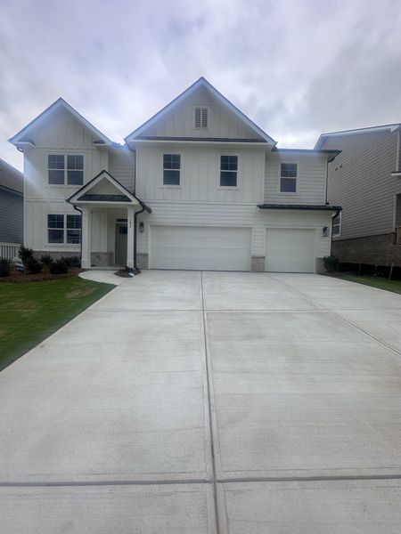 A charming white home with a spacious driveway in Hamptons at Riverwood South by D.R. Horton (Dallas, GA).