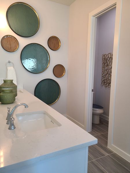 A modern bathroom with sleek surfaces, decorative wall art, and elegant fixtures.
