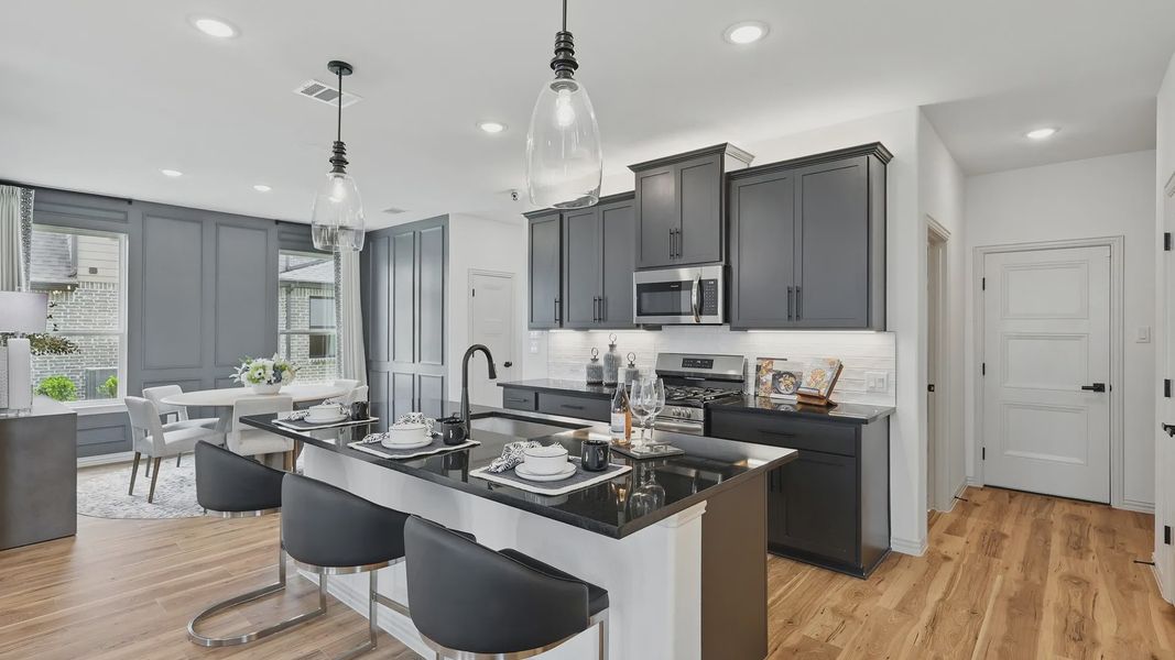 Luxurious Westridge kitchen featuring sleek black cabinetry, gourmet island, and polished wood flooring.