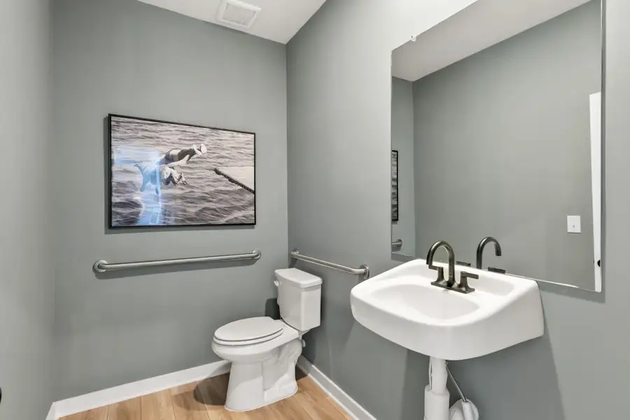 A bathroom with a picture on the wall.