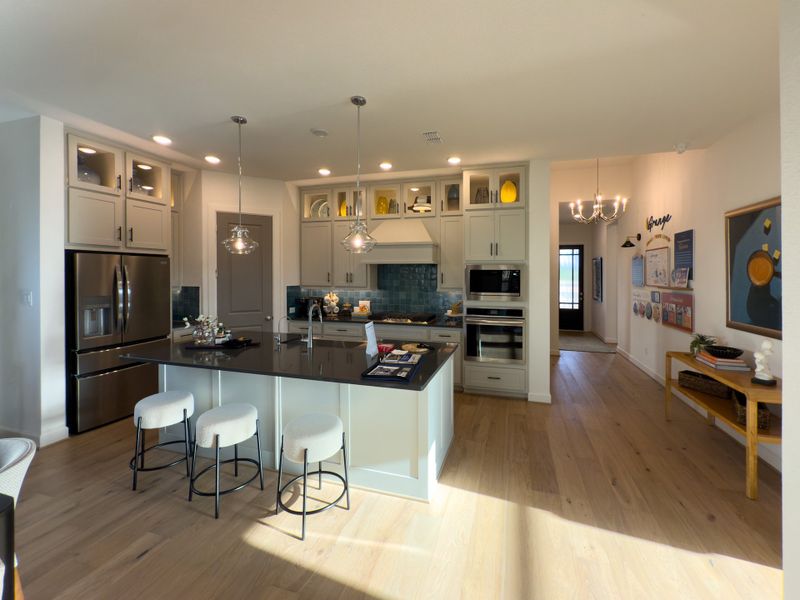 A modern kitchen with sleek cabinetry, a spacious island, pendant lighting, and stainless steel appliances. A modern kitchen with sleek cabinetry, a spacious island, pendant lighting, and stainless steel appliances.