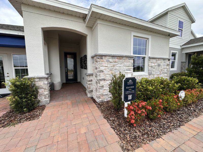 Charming home with stone accents and a welcoming entryway in Trinity Lakes by Trinity Family Builders (Groveland, FL).