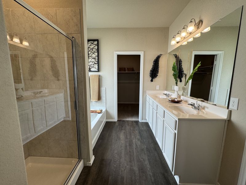 A modern bathroom with a spacious shower, dual sinks, sleek flooring, and elegant decor.