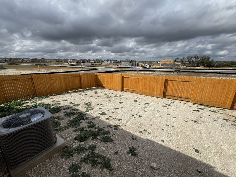 A spacious backyard with a privacy fence in Cool Water at Sonterra by LGI Homes (Jarrell, TX).