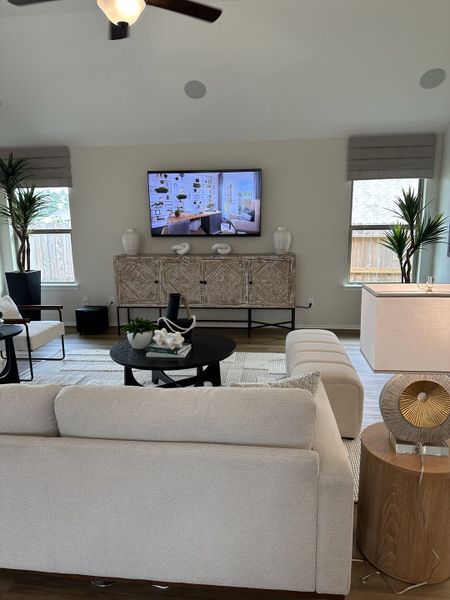 A modern living room with a cozy beige sofa, stylish TV setup, and chic decor elements.