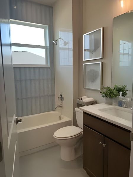 A contemporary bathroom with a sleek bathtub, elegant vanity, and decorative art accents on the wall.