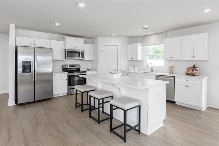 Bright, open main-level living with LVP flooring and granite countertops.