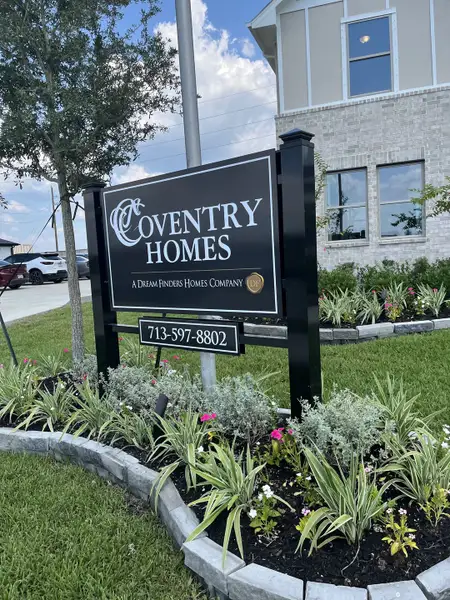 A beautiful landscaped entrance at Coventry Homes in Windcress, Cove, TX, featuring lush greenery and modern design.