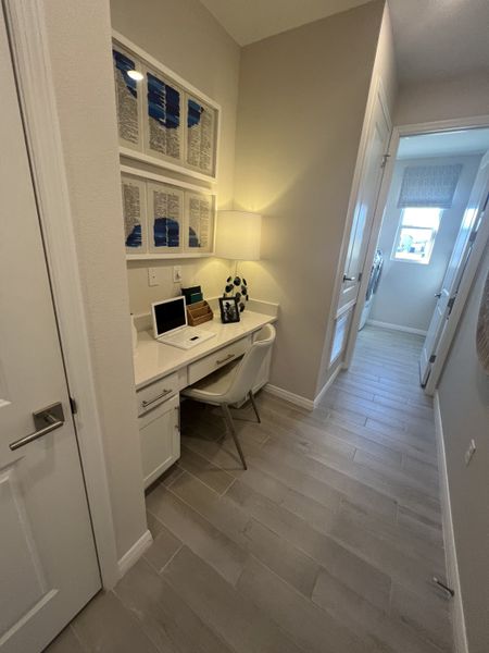 A cozy hallway workspace with built-in desk, modern decor, and stylish lighting.