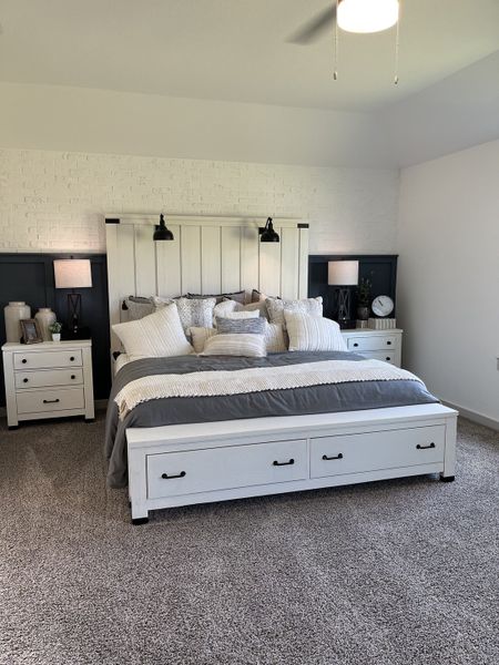 A cozy bedroom with a white brick accent wall, modern lamps, and plush carpeting. Perfect for restful slumber.