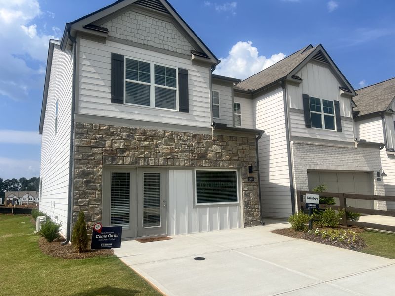 A charming stone-accented home with white siding in Rosewood Farms by D.R. Horton (Acworth, GA).