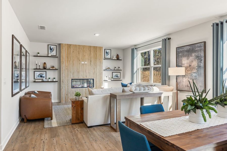 A living room with a table and chairs. A living room with a table and chairs.