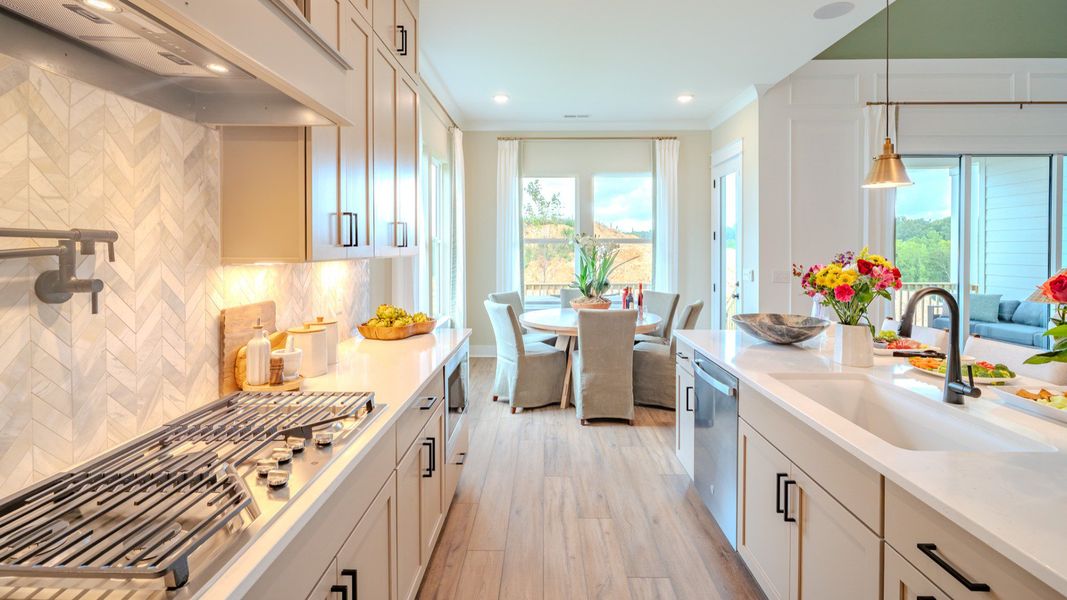 Kitchen with tile backsplash, quartz countertops, and pendant lighting Kitchen with tile backsplash, quartz countertops, and pendant lighting