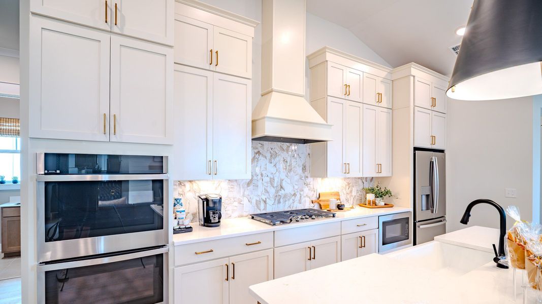 Kitchen with light cabinetry, quartz countertops, and tile backsplash