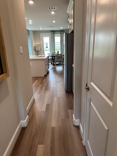 A bright hallway leading to an airy kitchen with wood floors and modern finishes. A bright hallway leading to an airy kitchen with wood floors and modern finishes.