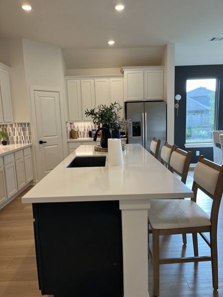 A modern kitchen with a sleek white island, stylish cabinetry, and stainless steel appliances. A modern kitchen with a sleek white island, stylish cabinetry, and stainless steel appliances.