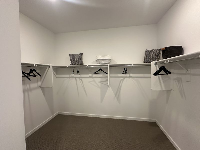 A large walk-in closet with white shelving and ample space for organized storage.