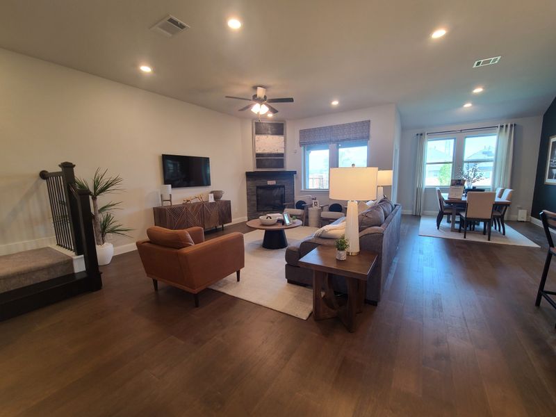 A cozy living room featuring a modern fireplace, elegant furnishings, and ample natural light from large windows.