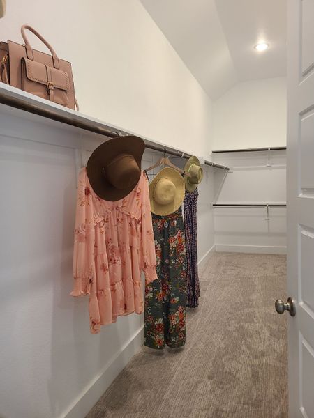 A spacious walk-in closet featuring ample shelving and hanging space with cozy carpet flooring. A spacious walk-in closet featuring ample shelving and hanging space with cozy carpet flooring.