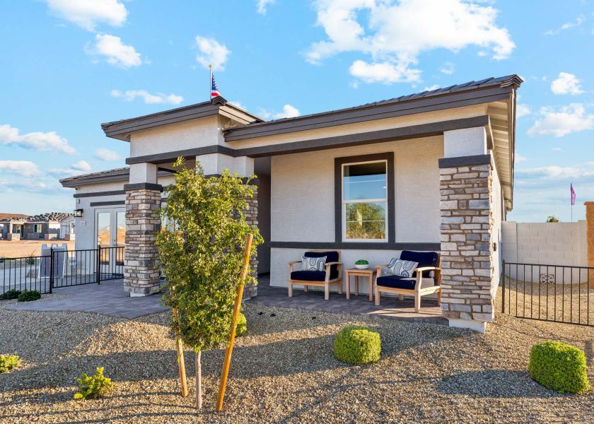 A house with a patio and a table and chairs in the front.