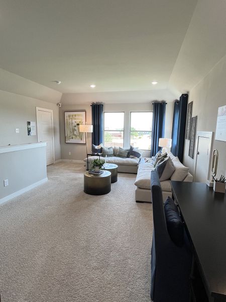A cozy living room with plush carpet, modern sectional, chic tables, and ample natural light from large windows. A cozy living room with plush carpet, modern sectional, chic tables, and ample natural light from large windows.
