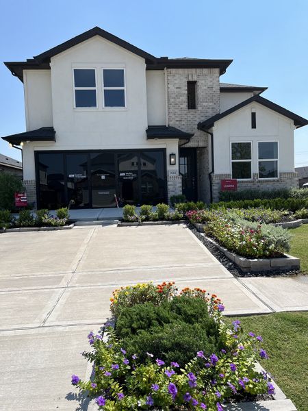 A modern two-story home with a landscaped yard in Bridge Creek 45s and 50s by Taylor Morrison (Cypress, TX).