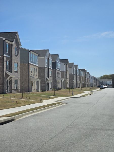A row of elegant townhomes with brick facades in The Beacon at Old Peachtree by Stanley Martin Homes, Lawrenceville, GA.