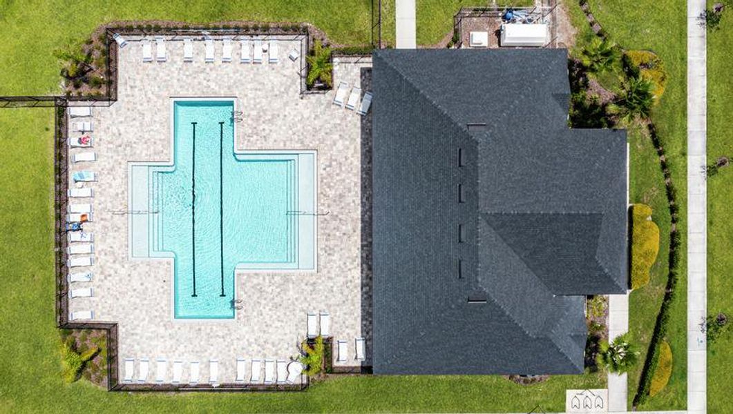 Bird's-eye view of a sparkling blue swimming pool and a community clubhouse.