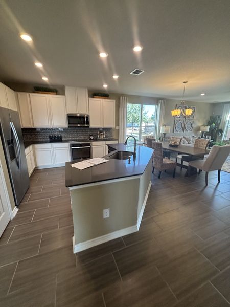 A modern kitchen with sleek cabinetry, stainless steel appliances, and an open layout connecting to a cozy dining area. A modern kitchen with sleek cabinetry, stainless steel appliances, and an open layout connecting to a cozy dining area.