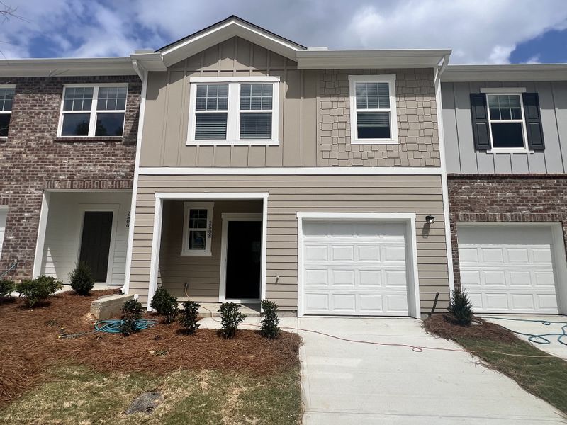 A charming townhome with a modern facade and landscaped entry in Aviary Park by Starlight Homes (Atlanta, GA).