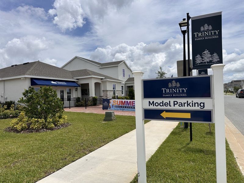 A charming community entrance with model parking signs in Trinity Lakes by Trinity Family Builders in Groveland, FL.