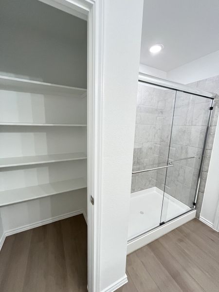 A modern bathroom with a glass-enclosed shower and adjacent open shelving, featuring sleek tile and soft lighting. A modern bathroom with a glass-enclosed shower and adjacent open shelving, featuring sleek tile and soft lighting.