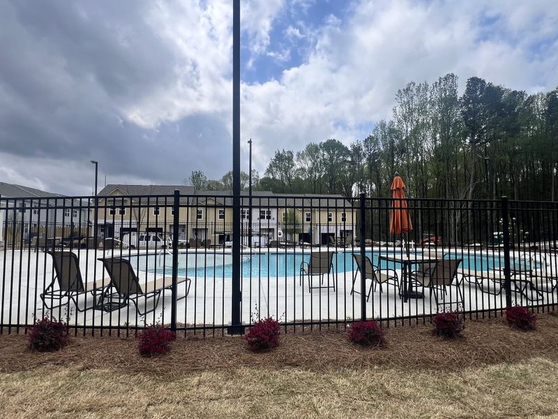 A lovely community pool area with lounge chairs and umbrellas in Aviary Park by Starlight Homes, Atlanta, GA.