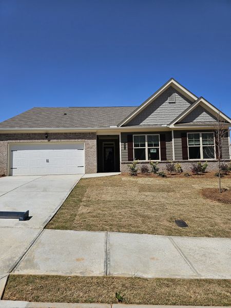 A charming brick home with a neat front yard in Hellen Valley by McKinley Homes (Braselton, GA).