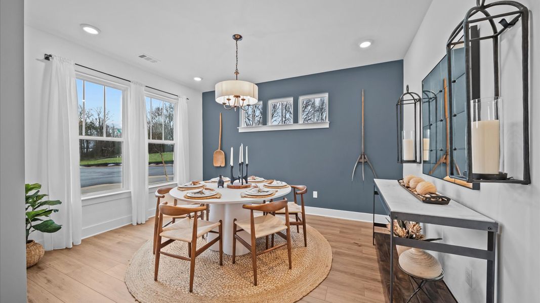 Inviting, spacious dining room with large windows, hardwood flooring, chandelier, and elevated ceilings Inviting, spacious dining room with large windows, hardwood flooring, chandelier, and elevated ceilings