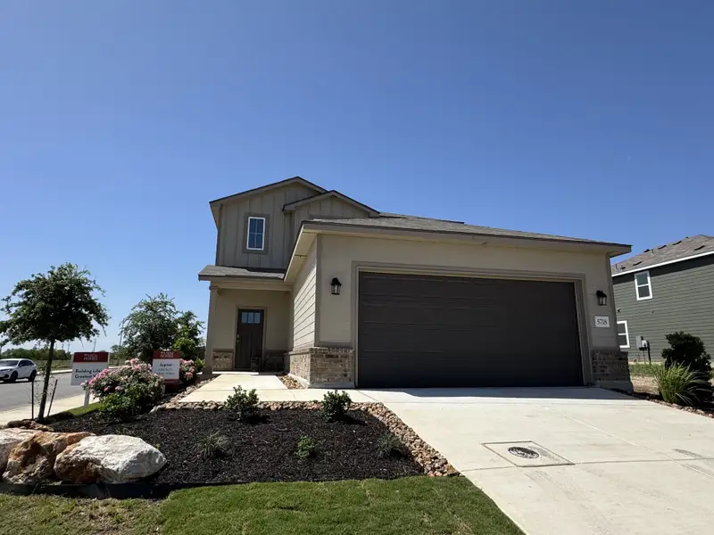A charming two-story home with modern design in Blue Ridge Ranch by View Homes, featuring a landscaped yard (San Antonio, TX).