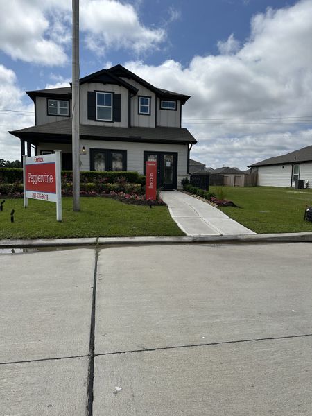 A charming two-story home with landscaped accents in Peppervine by Centex, Porter, TX.
