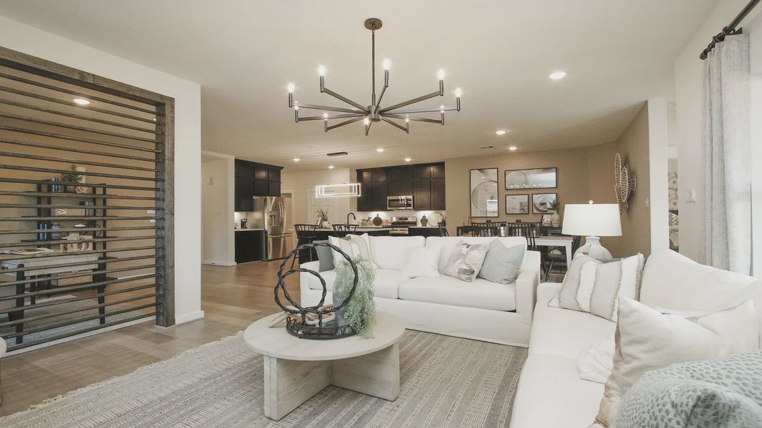 Discover open elegance with a sleek chandelier and refined kitchen in Colony at Pinehurst, Texas.