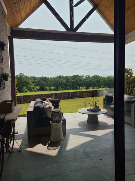 A cozy patio with modern sofas, chic decor, and lush lawn views ideal for relaxation. A cozy patio with modern sofas, chic decor, and lush lawn views ideal for relaxation.