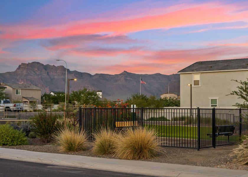 A fenced in area with a building and mountains in the background. A fenced in area with a building and mountains in the background.
