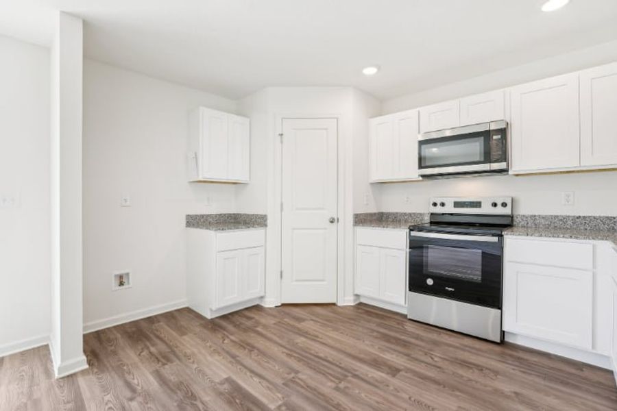 A kitchen with white cabinets.