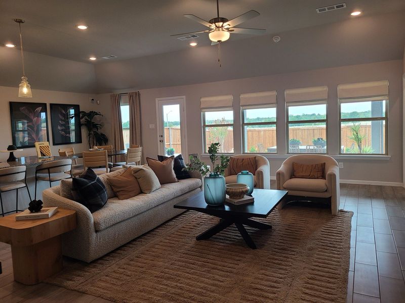 A contemporary living room with a cozy sofa, modern chairs, and large windows bringing in natural light. A contemporary living room with a cozy sofa, modern chairs, and large windows bringing in natural light.